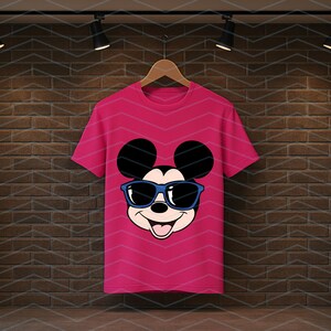 K&ouml;nnte beinhalten: Ein leuchtend pinkfarbenes Kurzarm-T-Shirt mit einem Grafikdruck von Mickey Mouse, der eine blau umrandete Sonnenbrille tr&auml;gt. Die Figur hat gro&szlig;e schwarze Ohren, ein l&auml;chelndes Gesicht und ist mittig auf der Vorderseite platziert.