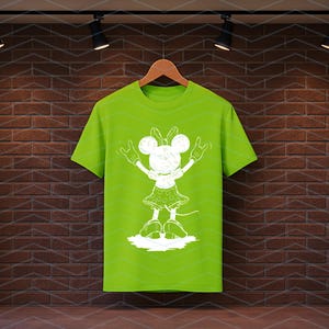 May include: A lime green t-shirt with a white cartoon character graphic, bow, hands raised, and a polka dot skirt. The shirt hangs on a wooden hanger against a brick wall.
