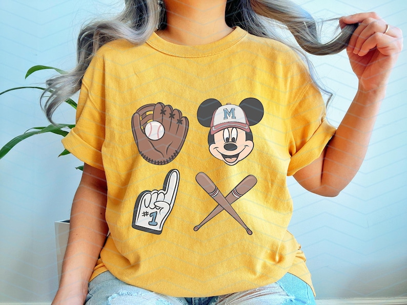 May include: A yellow t-shirt with a baseball glove, baseball bat, and Mickey Mouse graphic. The Mickey Mouse graphic has a baseball cap on and says "M" on it. The t-shirt also has a number "1" with a finger pointing up.