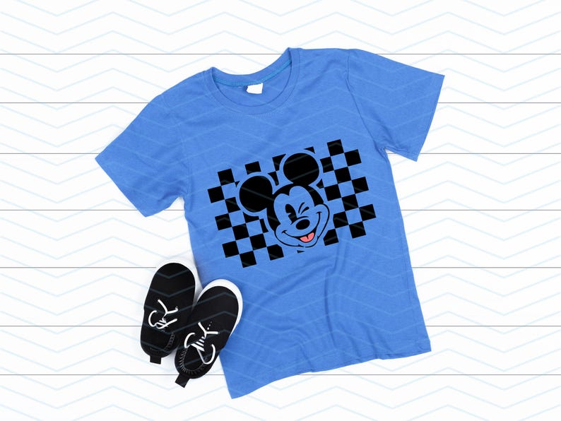 May include: A blue t-shirt with a black and white checkered pattern and a black and white cartoon image of Mickey Mouse winking with his tongue sticking out.