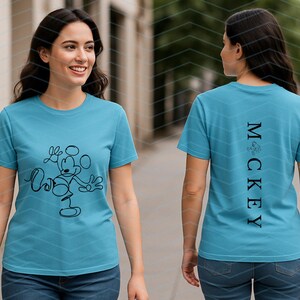 Puede incluir: Una camiseta azul brillante de manga corta con un dibujo de l&iacute;nea continua negra de un rat&oacute;n de dibujos animados en la parte delantera. La parte posterior muestra el texto vertical negro "M C K E Y" con un peque&ntilde;o gr&aacute;fico circular sobre la M.