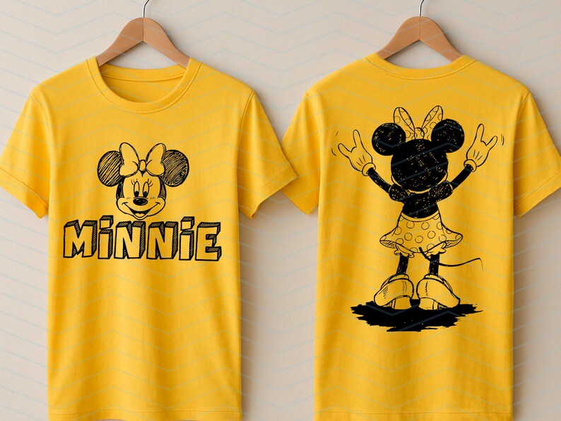 May include: Yellow t-shirt with a black and white Minnie Mouse design. The front shows Minnie's face and the name "MINNIE". The back features a silhouette of Minnie Mouse with her arms up. The t-shirt is hanging on a wooden hanger.