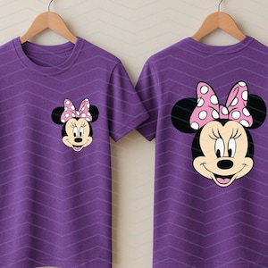 May include: Two purple t-shirts with a Minnie Mouse graphic. The front of the shirt has a small Minnie Mouse face, and the back has a larger Minnie Mouse face. Both have a pink bow with white polka dots.
