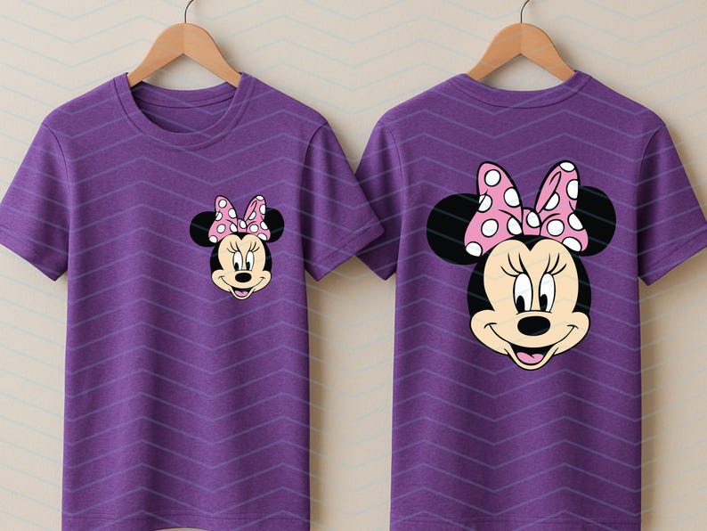May include: Two purple t-shirts with a Minnie Mouse graphic. The front of the shirt has a small Minnie Mouse face, and the back has a larger Minnie Mouse face. Both have a pink bow with white polka dots.