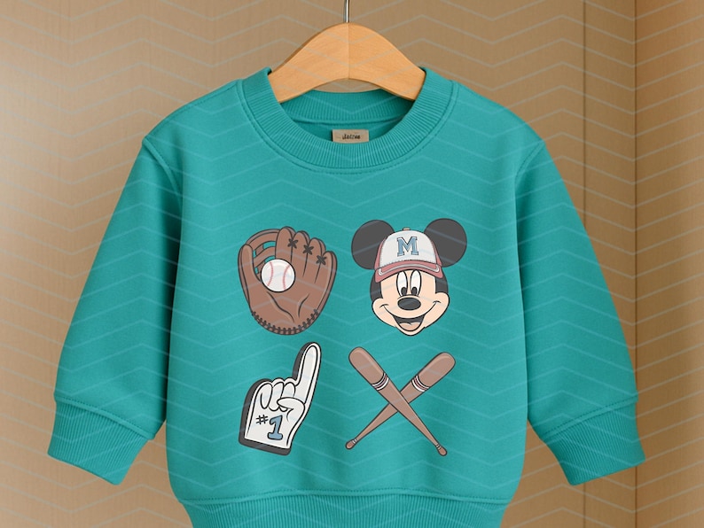 May include: A teal blue sweatshirt with a baseball glove, baseball, and Mickey Mouse graphic. The Mickey Mouse graphic has a baseball cap with the letter "M" on it. The text "#1" is on the graphic of a raised finger.