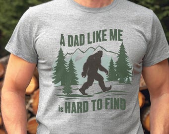 Funny Bigfoot Dad Shirt, A Dad Like Me Is Hard To Find Tee, Sasquatch Father’s Day Gift, Wilderness Dad T-Shirt, Forest Style Tees