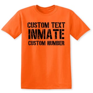 May include: Orange t-shirt with black text that reads "CUSTOM TEXT INMATE CUSTOM NUMBER".