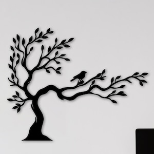 Può includere: Arte murale in metallo nero raffigurante un albero con un uccello posato su un ramo. L'albero presenta foglie dettagliate e un tronco curvo. L'opera è montata su una parete bianca, creando un contrasto suggestivo.