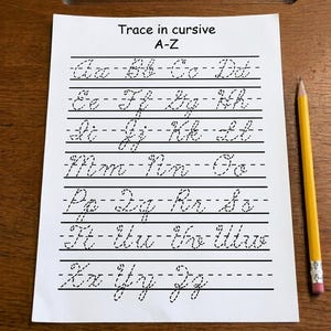Może przedstawiać: Biały arkusz ćwiczeniowy z napisem Trace in cursive A-Z zawierający czarne przerywane litery alfabetu ułożone w rzędach na papierze w linie. Żółty drewniany ołówek z różową gumką znajduje się pionowo po prawej stronie papieru.