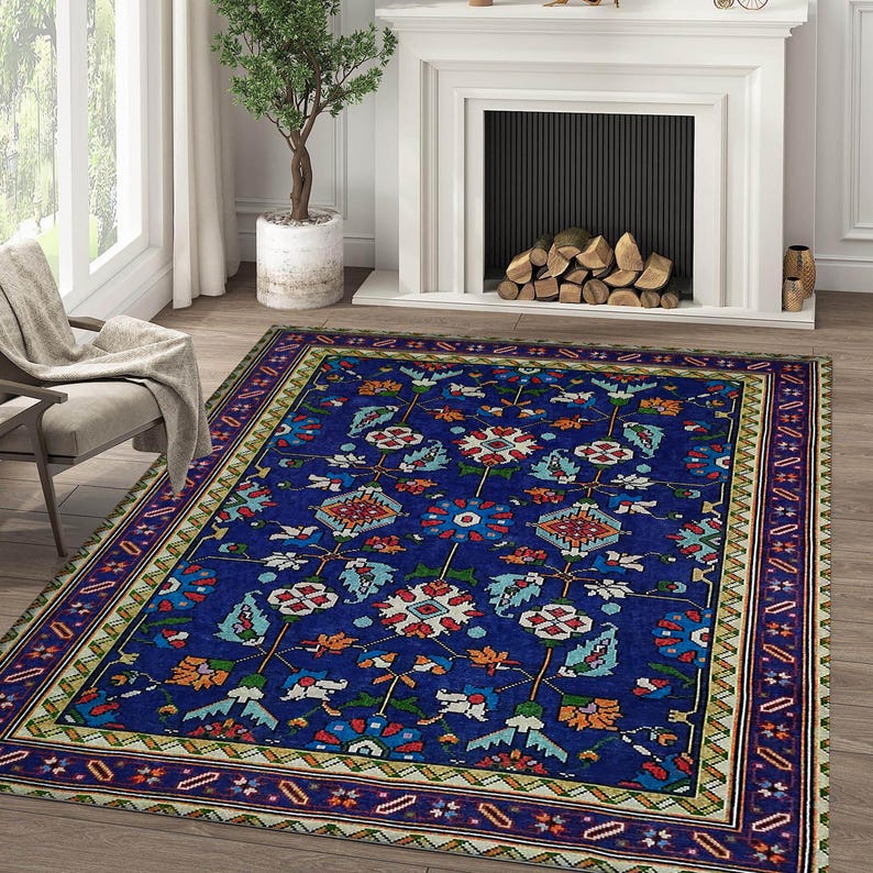 May include: A blue and cream patterned rug with a floral design. The rug has a dark blue border with a geometric pattern.