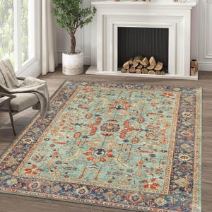 May include: A teal blue area rug with a traditional Persian design featuring intricate floral patterns in shades of red, orange, and cream. The rug has a dark blue border with a geometric pattern.