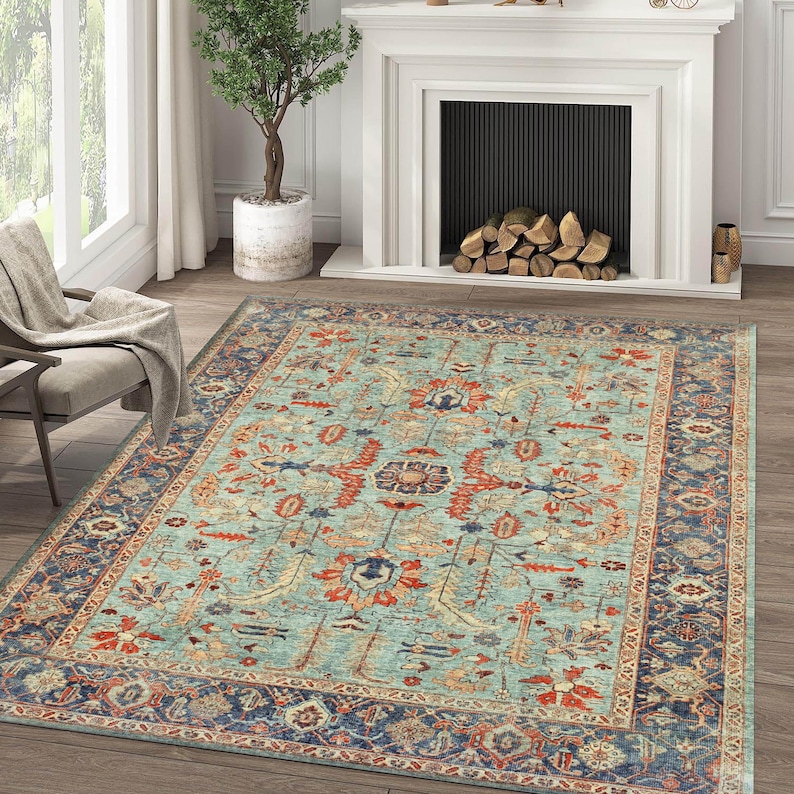 May include: A teal blue area rug with a traditional Persian design featuring intricate floral patterns in shades of red, orange, and cream. The rug has a dark blue border with a geometric pattern.