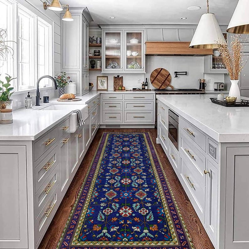 May include: A blue and white patterned rug runner with floral designs in a kitchen with white cabinets and a white worktop.