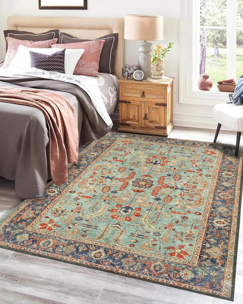 May include: A teal blue area rug with a traditional Persian design featuring intricate floral patterns in shades of red, orange, and cream. The rug has a dark blue border with a geometric pattern.