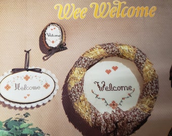 Folleto de patrones de punto de cruz vintage "Wee Welcome" con patrones para la palabra "Welcome" (1982, bk4258)