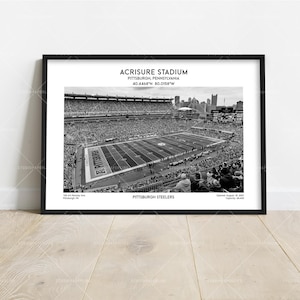May include: Monochrome framed print of Acrisure Stadium in Pittsburgh, Pennsylvania. The image shows a packed stadium with a football field. Text includes the stadium name, location, and team name, Pittsburgh Steelers.