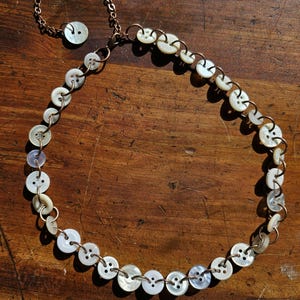 Collar de botón blanco