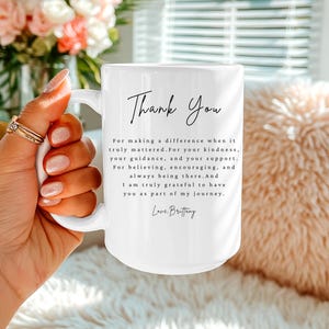 Puede incluir: Taza de cer&aacute;mica blanca con las palabras "Thank You" en escritura elegante. La taza presenta un mensaje sincero de gratitud, incluyendo las palabras "For making a difference" y "Love, Brittany."