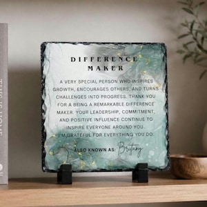 May include: A square slate plaque with rough, chipped edges featuring a green and white watercolor-style background with gold flecks. The text reads: DIFFERENCE MAKER. A VERY SPECIAL PERSON WHO INSPIRES GROWTH, ENCOURAGES OTHERS, AND ALSO KNOWN AS: Brittany.