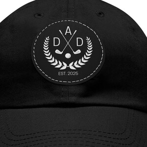 May include: Black baseball cap with a circular patch featuring the word "DAD" with crossed golf clubs, a golf ball, and laurel leaves. The patch also includes the text "EST. 2025".
