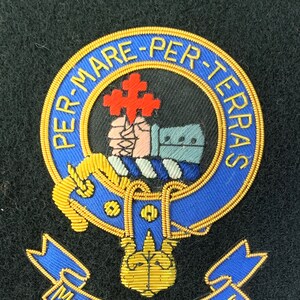 Può includere: Uno stemma ricamato in blu e oro con il testo "Per Mare Per Terras" e "McDonald of Sleat".