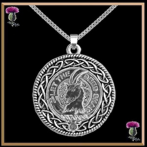 May include: Silver pendant necklace. The circular pendant features Celtic knotwork and a central goat emblem. The words "LET THE DEED SHAW" are inscribed around the goat image. The necklace has a fine chain, suitable for everyday wear.