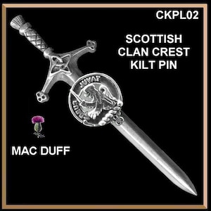May include: Silver Scottish clan crest kilt pin featuring a sword and a shield with a lion and the text "Deus Juvat". The pin is on a black background with the text "CKPL02" and "MAC DUFF" in white.