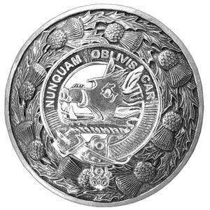 May include: A silver-toned metal clan crest featuring a boar's head with a crown and the text "NUNQUAM OBLIVISCAR" surrounded by a wreath of thistles.