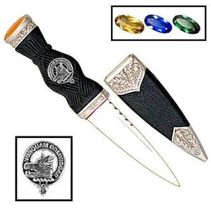 May include: A black and silver Scottish Sgian Dubh with a silver crest and a black leather scabbard. The crest features a wolf's head and the text "Nunquam Oblivioscar".