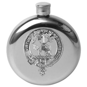 May include: A silver stainless steel hip flask with a round shape and a hinged cap. The flask features an engraved crest with a vine, a hand holding a knife, and the text "Virtus Vulnere Virescit".