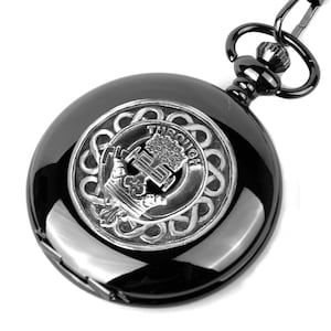 Puede incluir: Reloj de bolsillo negro con un escudo plateado que presenta un árbol y la palabra "Through" sobre un fondo negro.
