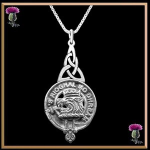 May include: Silver pendant necklace featuring a Celtic knot design and a circular crest with a wolf's head and the text "S Rioghal Mo Dhrean".