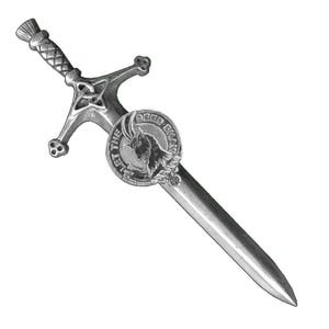 May include: A silver-coloured kilt pin in the shape of a sword with a Celtic knot design. The sword has a round shield with a goat head and the text "DEED SMA'  "PIET THE" on it.