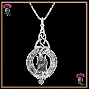 May include: Silver pendant necklace featuring a Celtic knot design and a circular crest with a goat head and the text "Let the Deed Shaw".