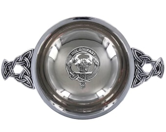 May include: A silver-toned bowl with Celtic knot handles. The bowl's interior reflects light, and a circular emblem with the words "HOLD FAST" is centered inside. The handles are intricately designed with interwoven patterns.