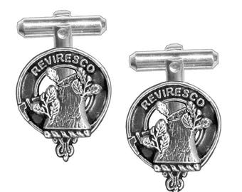 Puede incluir: Un par de gemelos de plata con el escudo de armas del clan escocés Reviresco. El escudo es un tocón de árbol con hojas y el lema del clan, "Reviresco", está inscrito alrededor del escudo.