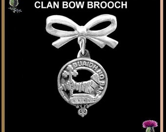 May include: Silver clan bow brooch with a white bow and a silver crest featuring a lion and the text "BUAIDH NO BAS".