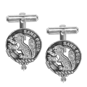 May include: A pair of silver cufflinks featuring a black and white crest with a lion and the text "SANS PEUR".