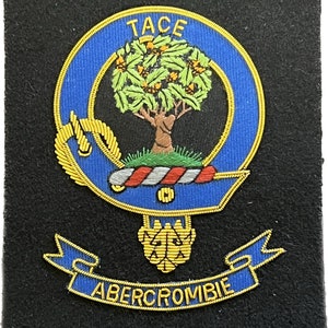 May include: A blue and gold embroidered crest with a tree, a ribbon with the text "TACE ABERCROMBIE", and a gold tassel. The crest is on a black background.