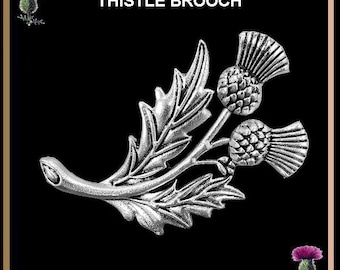 Puede incluir: Broche de cardo plateado con hojas detalladas y dos cabezas de flores de cardo. El broche está sobre un fondo negro con las palabras "THISTLE BROOCH" en la parte superior. Pequeñas ilustraciones de cardos en las esquinas.