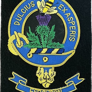 Può includere: Uno stemma ricamato in blu e oro con un'ape e un cardo, circondato dal testo "Dulcius Exasperis" e uno stendardo con il testo "Ferguson".