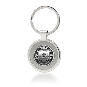 May include: Silver-toned keyring with a round metal tag featuring a black and white crest with the text "Mc Loughlin".