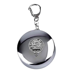 May include: A silver keychain with a round, silver-colored disc featuring a crest with the text "S Rioghal Mo Dhire".