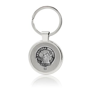 May include: Silver keychain with a round metal charm featuring a crest with the text "ABSCISSA VIRESQUIT".