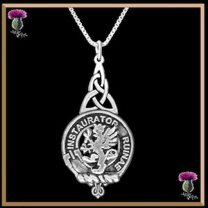 Op de afbeelding: Zilveren ketting met hanger met een Keltisch knoopontwerp en een rond schild met de woorden "INSTAURATOR RUINAE" en een heraldische leeuw.
