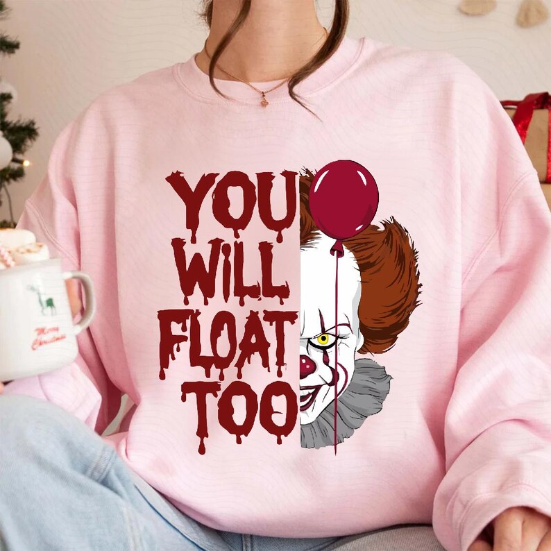 May include: Pink sweatshirt with a graphic of Pennywise the clown from the movie "IT" with the text "You Will Float Too".