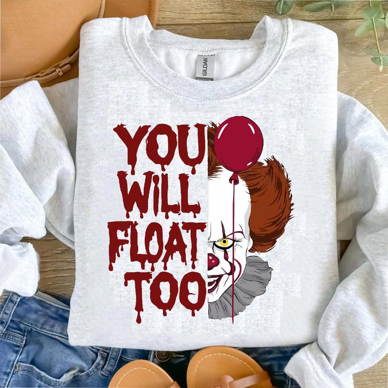 May include: A gray sweatshirt with a red and white graphic of Pennywise the clown from the movie "It". The graphic includes the text "You Will Float Too" and a red balloon.