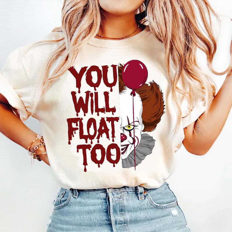 May include: A white t-shirt with a red graphic of Pennywise the clown from the movie "IT" with the text "YOU WILL FLOAT TOO" in red dripping letters.