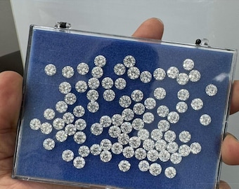 May include: A close-up view of a blue box filled with loose, round, lab-grown diamonds. The diamonds are various sizes, ranging from 1.0 to 2.0 carats and 6.50 to 8.0 millimetres. The diamonds are DEF colour and VVS/VS clarity.
