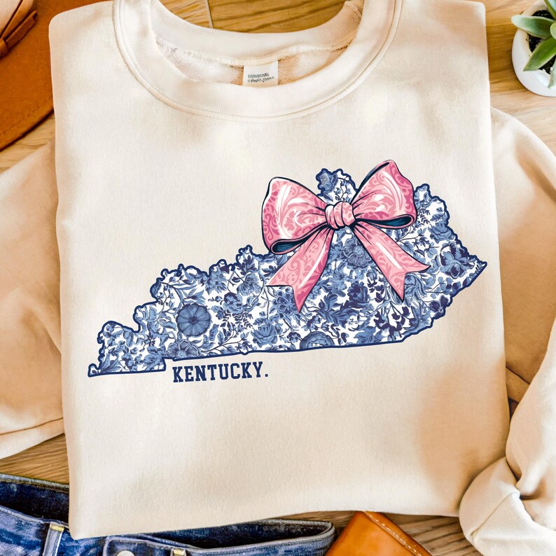 Kentucky state outline with blue and white Chinoiserie floral pattern and pink coquette bow PNG design.